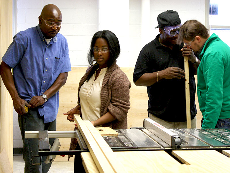 four architectural students working at a sawing table