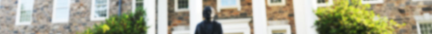 blurred photo banner of Douglass statue in front of Holmes Hall