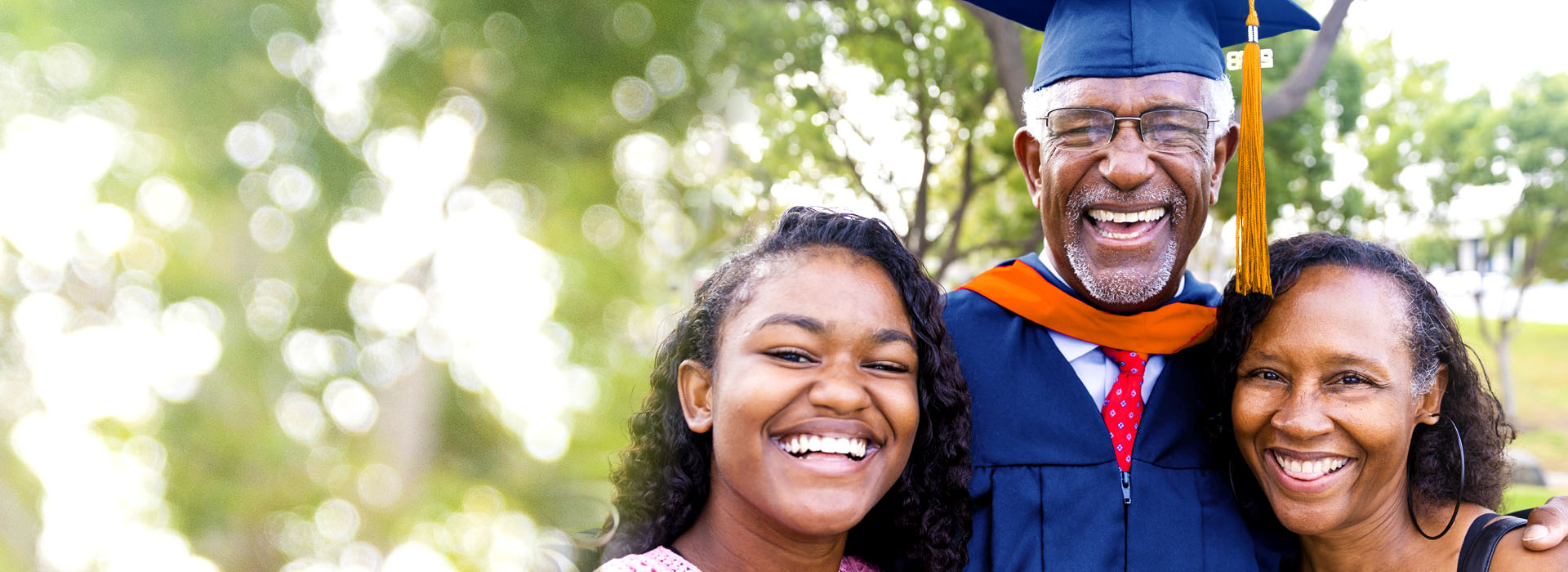 smiling adult graduate with his family