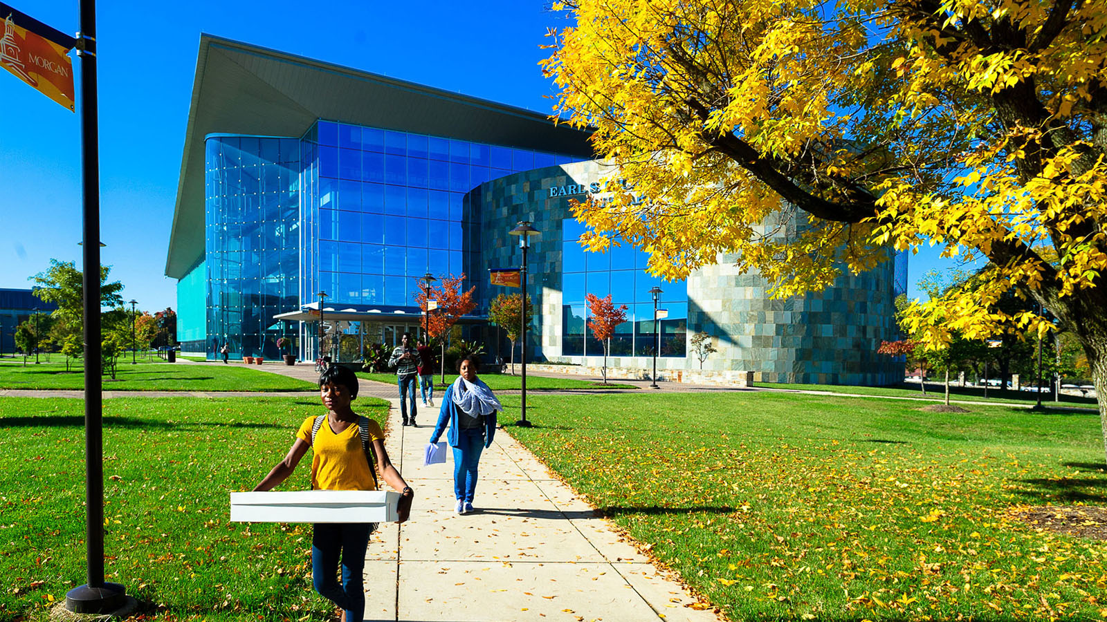 students walking on sidewalk from library