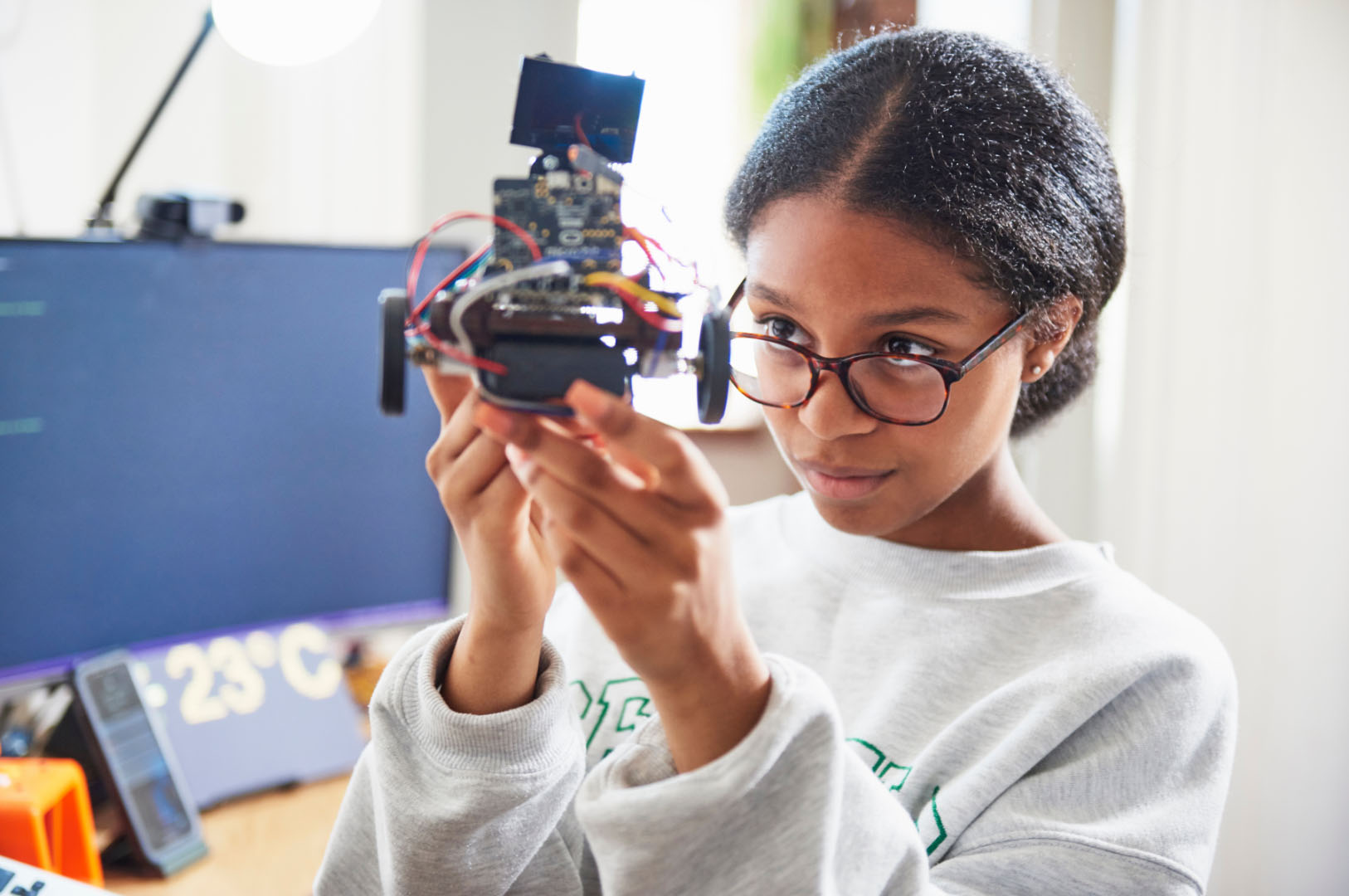 Black Female Teen studying a Robotics model