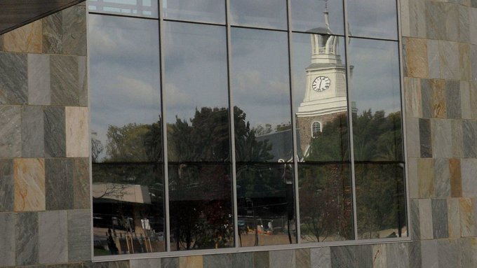 Holmes Hall reflecting off a window