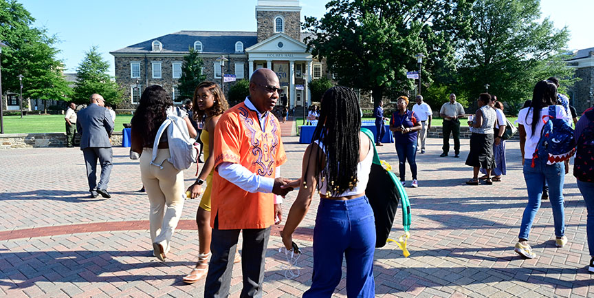 President Wilson shaking hands with student on the academic quad