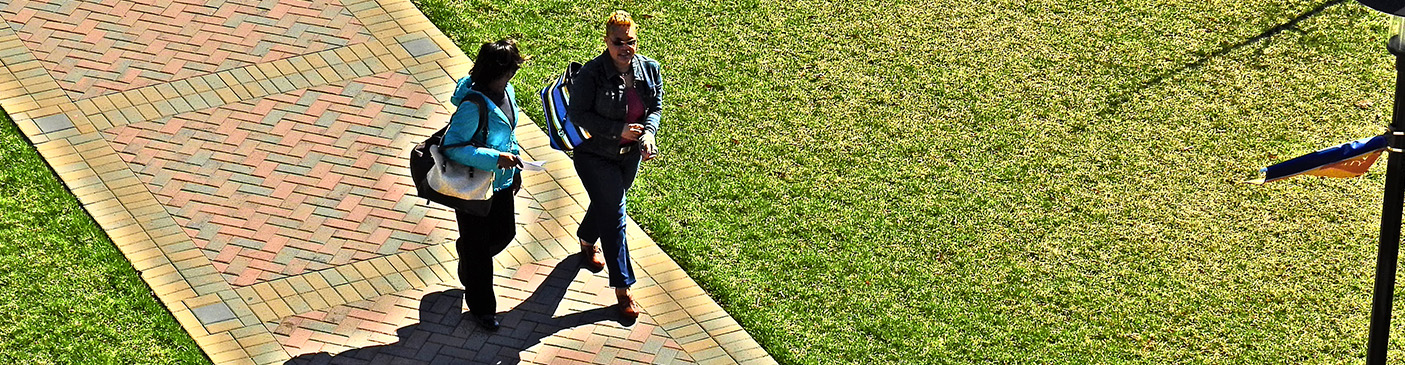 2 students walking on sidewalk